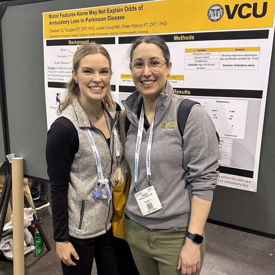 Chelsea Duppen standing with conference attendee in front of poster